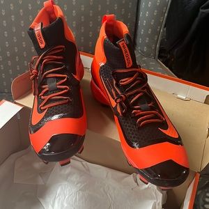 Orange and black Rubber on bottom —cleats. Football cleats.